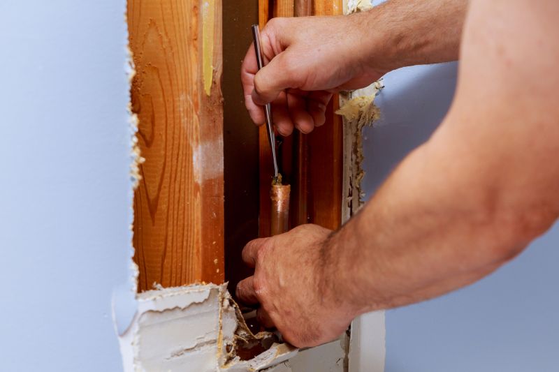 Handyman Fixing a Leaking Pipe